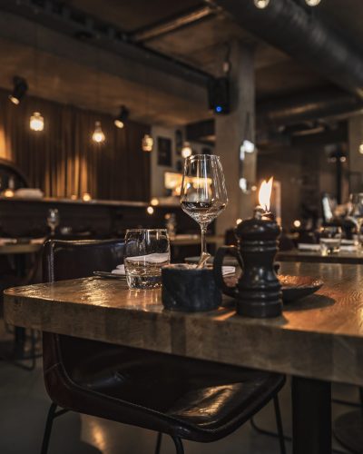 Cozy Evening in Luxury Restaurant. Beautiful Interior of Restaurant in Warm Mild Candlelight. Night Cafe. Urban Style. City Life.